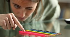mulher arrumando lápis colorida na mesa